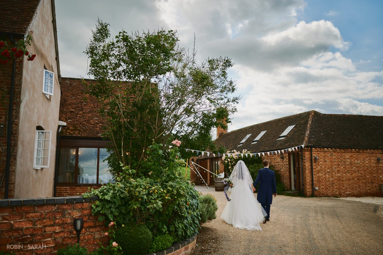 Bride and groom walking through courtyard at Wethele Manor