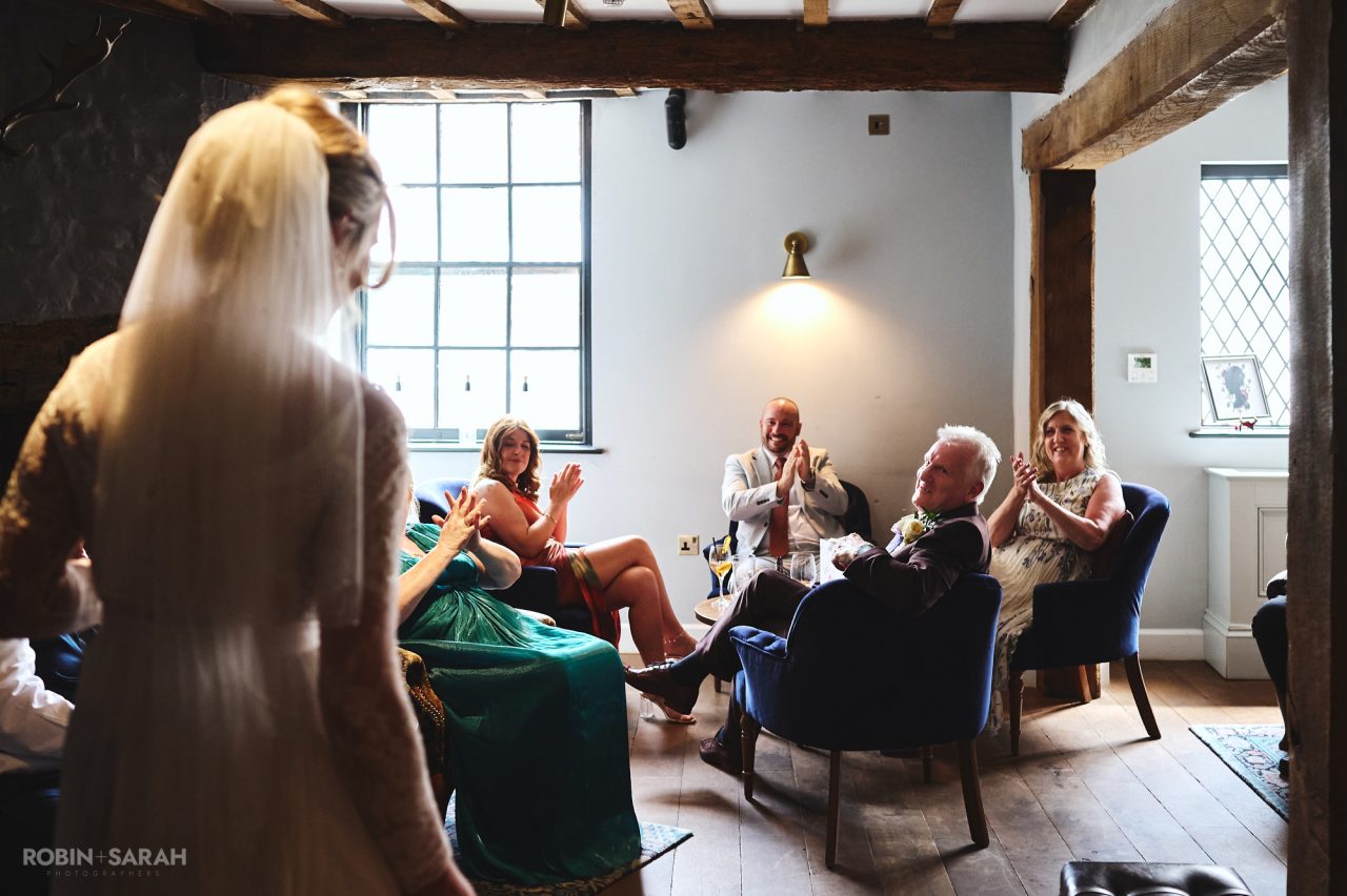 Wedding guests welcome bride to reception after registry office ceremony