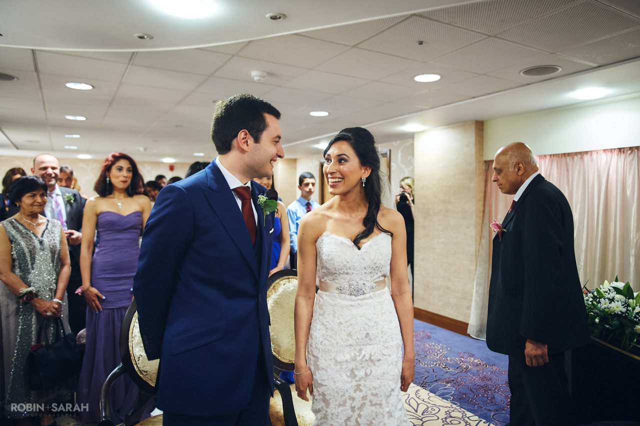 Bride and groom smile at each other at beginning of wedding ceremony at Solihull Register Office