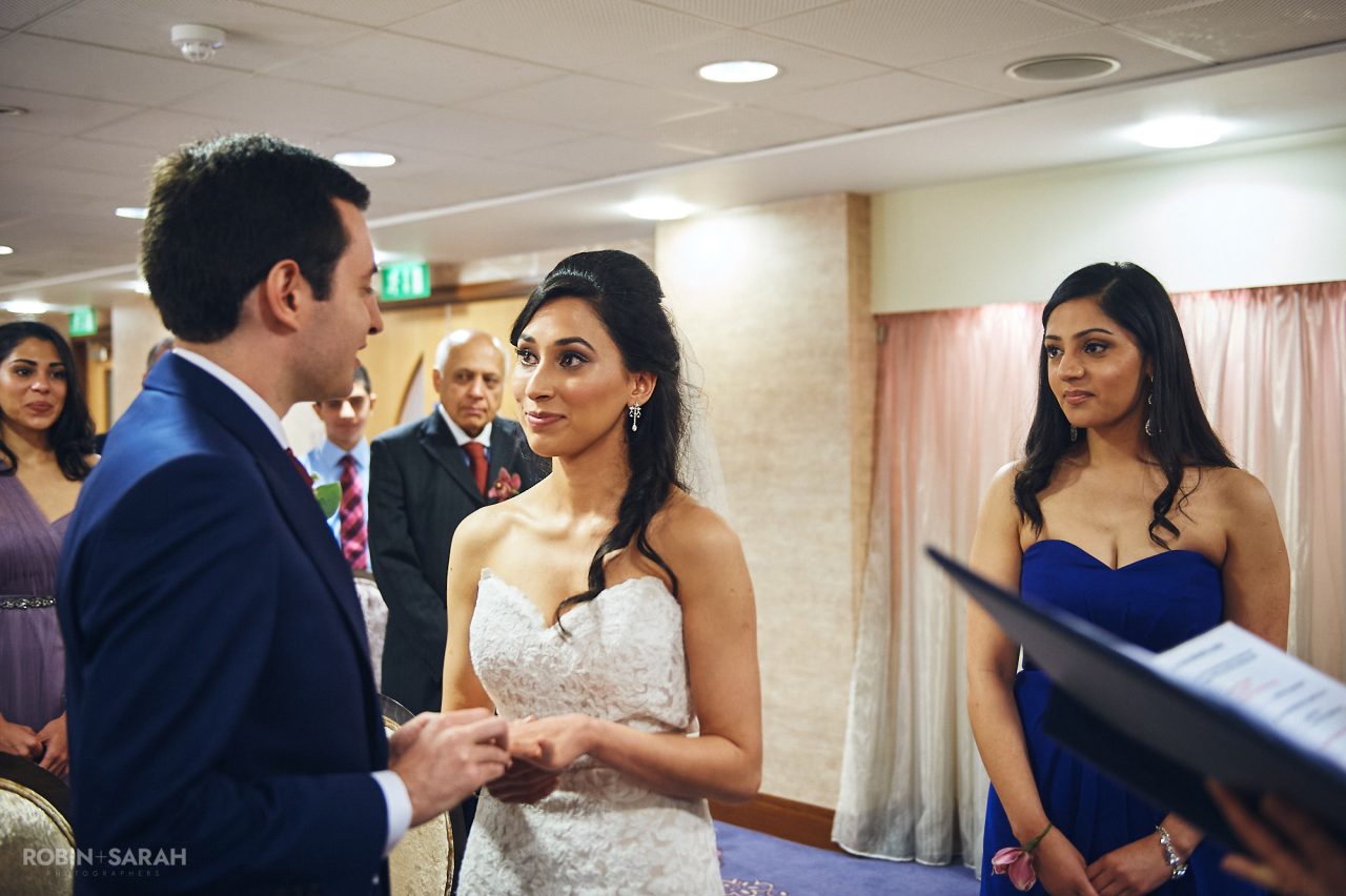 Bride and groom exchange wedding rings during ceremony at Solihull Register Office