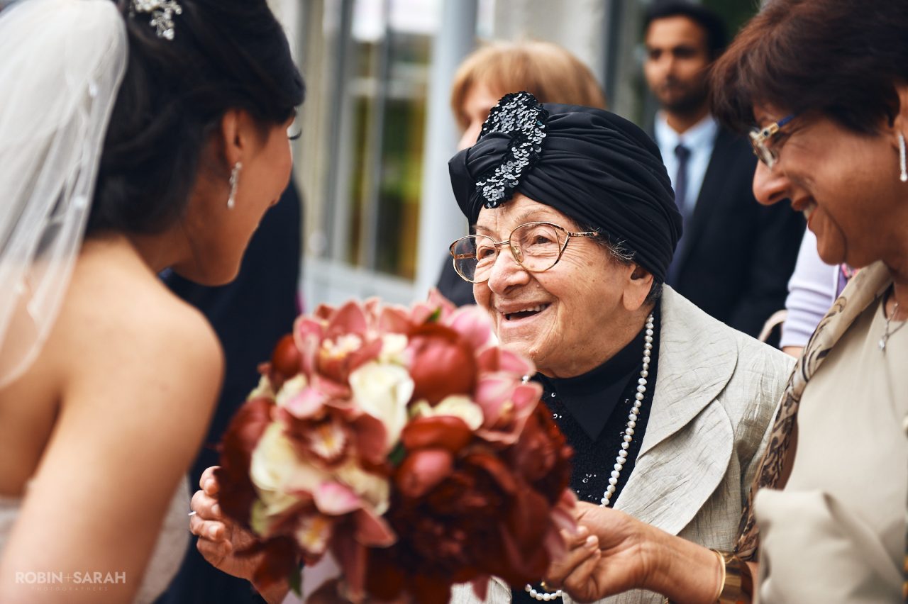 Elderly wedding guests smiles at bride after wedding ceremony