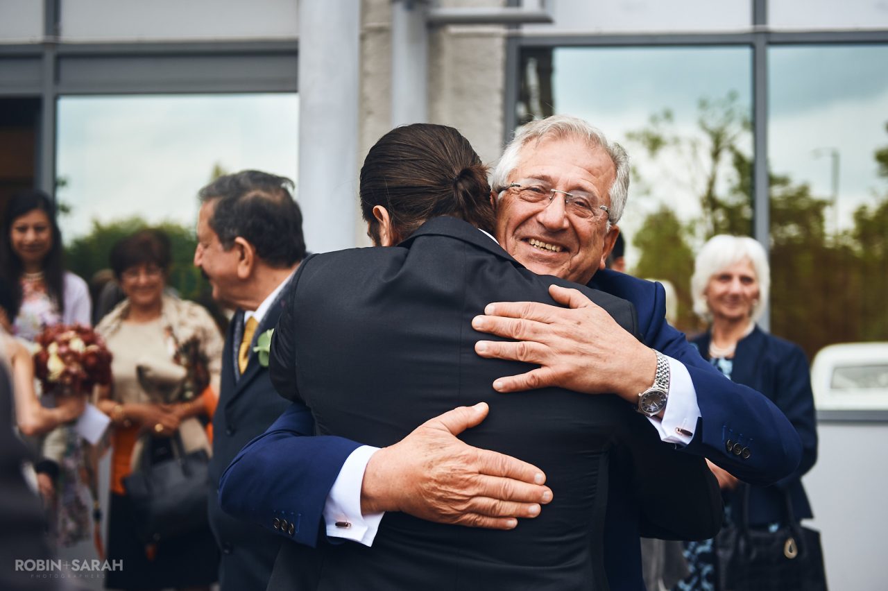 Bride's dad hugs son after wedding ceremony