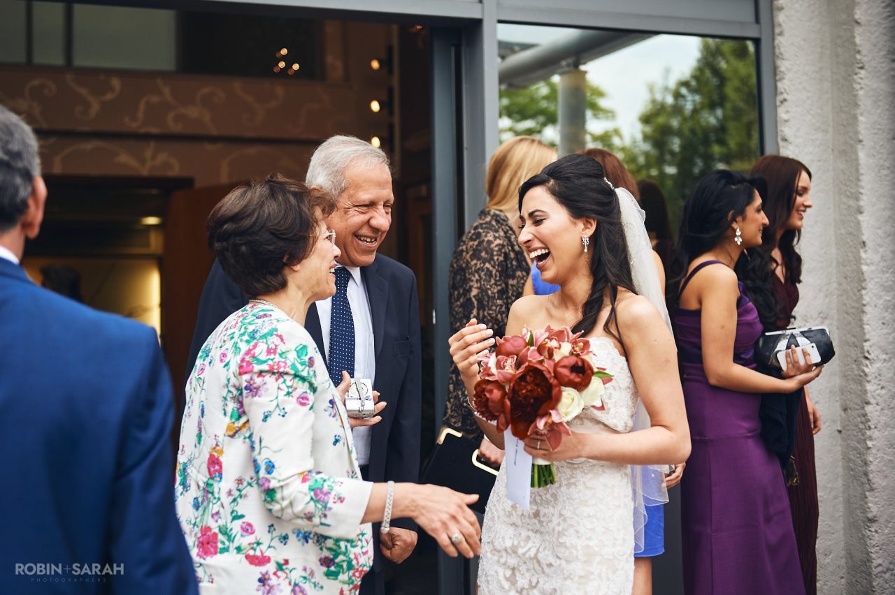 Bride laughing with wedding guests outside Solihull Register Office